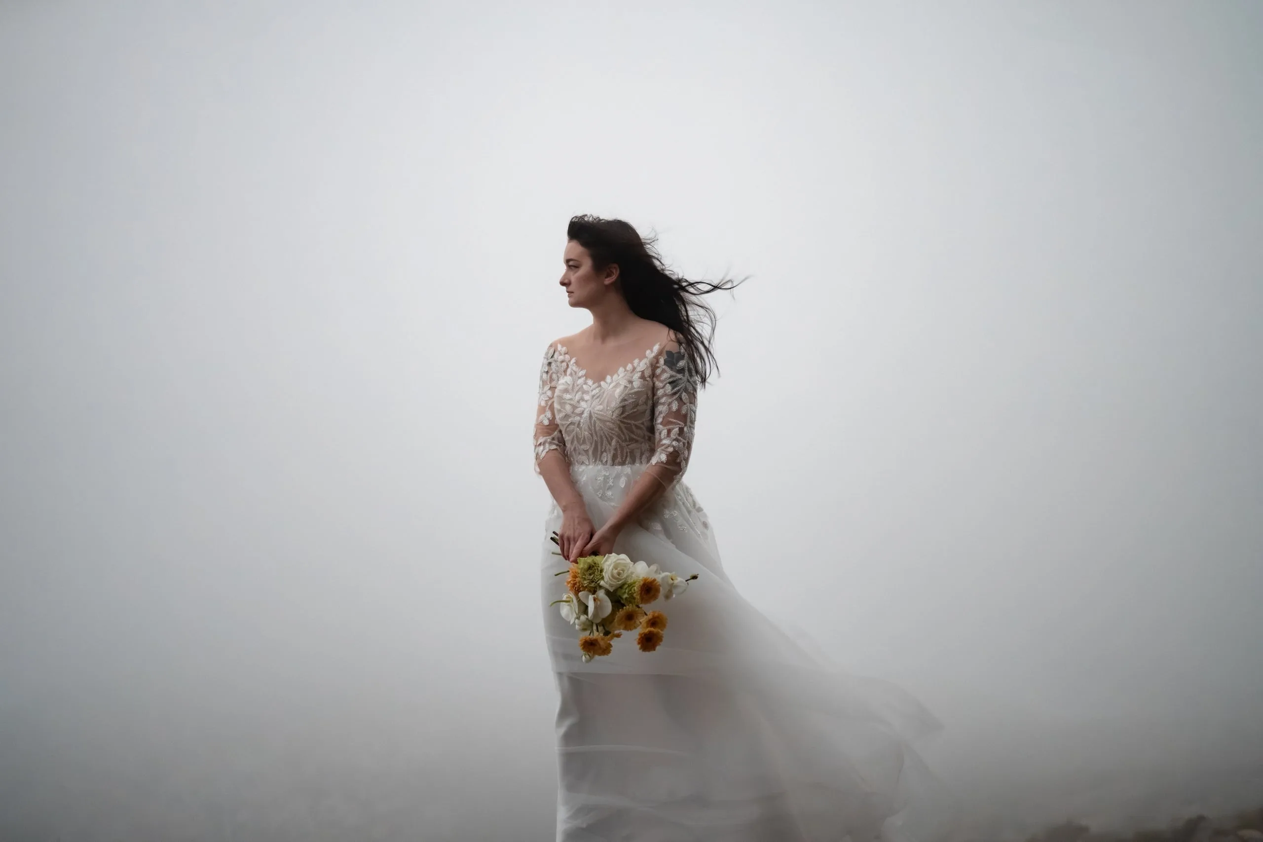 Braut im Nebel, der Wind spielt mit Haar und Kleid
