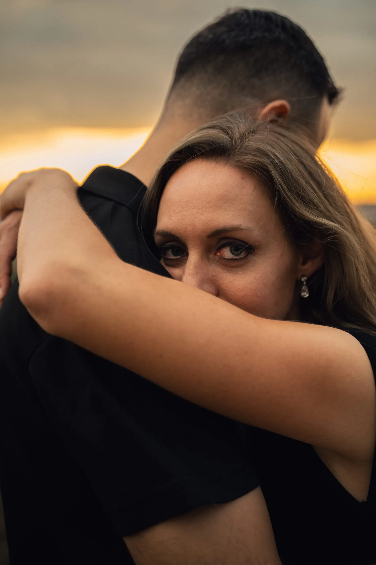Nahaufnahme: Martina schaut über Stephans Schulter in die Kamera, eng umarmt