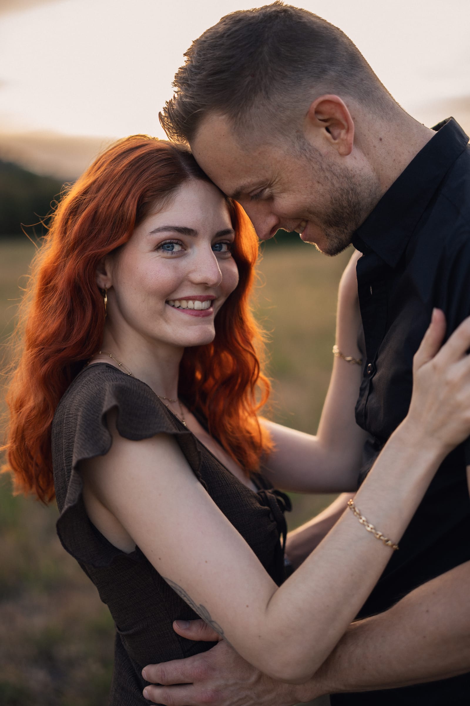 Tatjana lacht, Stirn an Stirn mit Yanick auf der Weide im Abendlicht