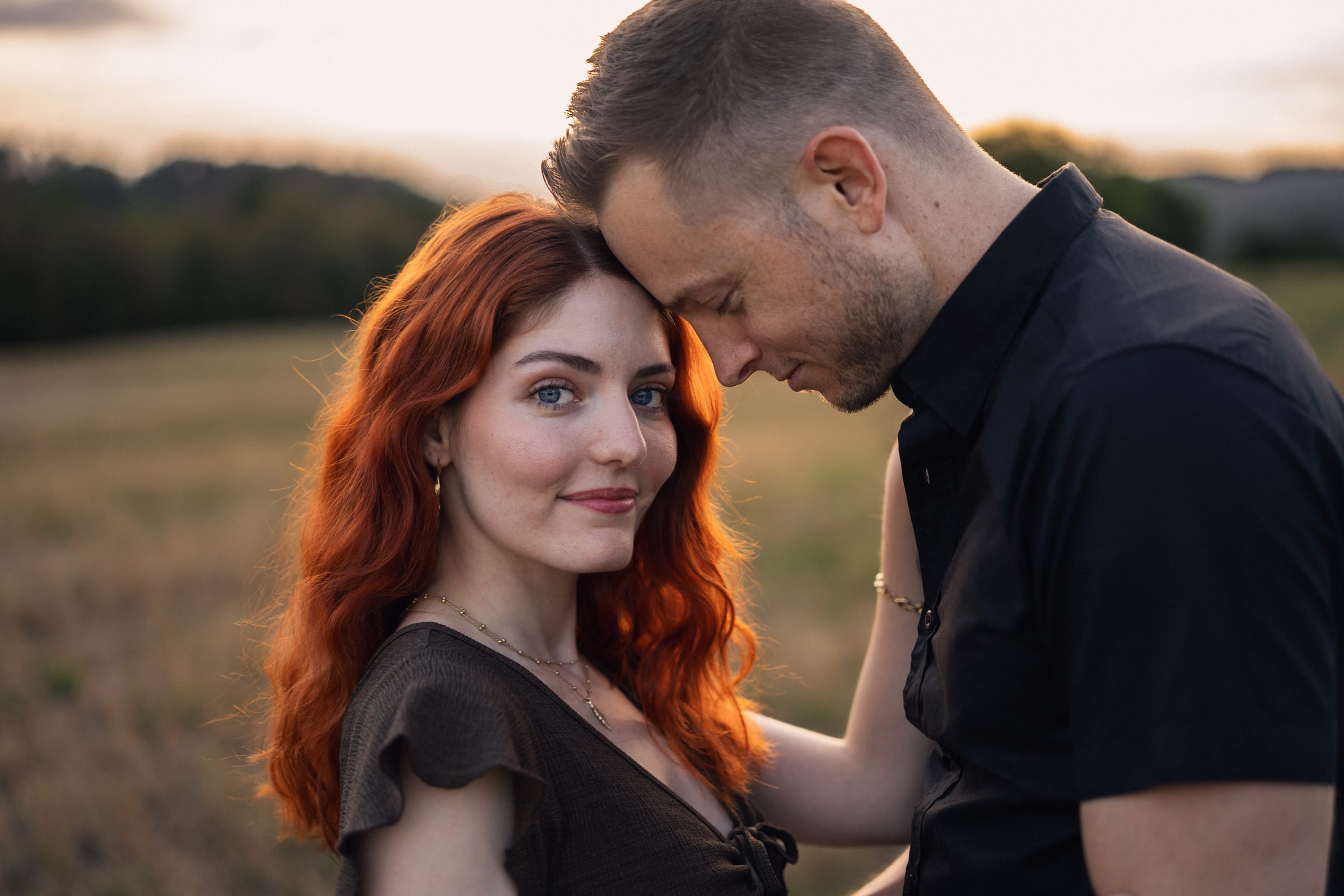 Yanick und Tatjana Stirn an Stirn, Querformat mit weitem Himmel über der Weide